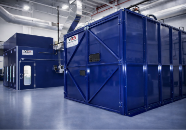 Large blue VES blast and paint enclosure installed inside an industrial facility.
