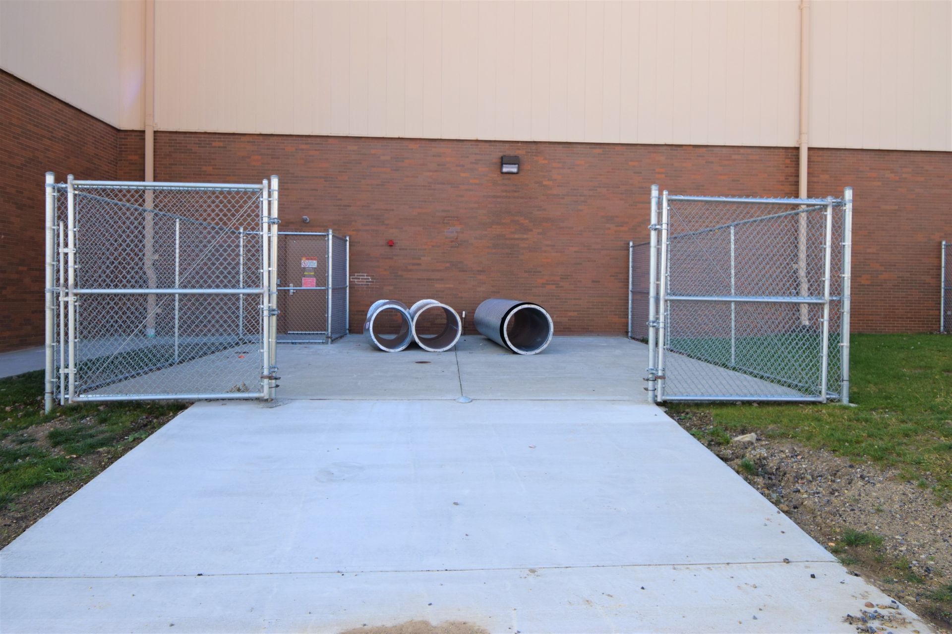 Installation site prepared for industrial equipment setup surrounded by chain link fence