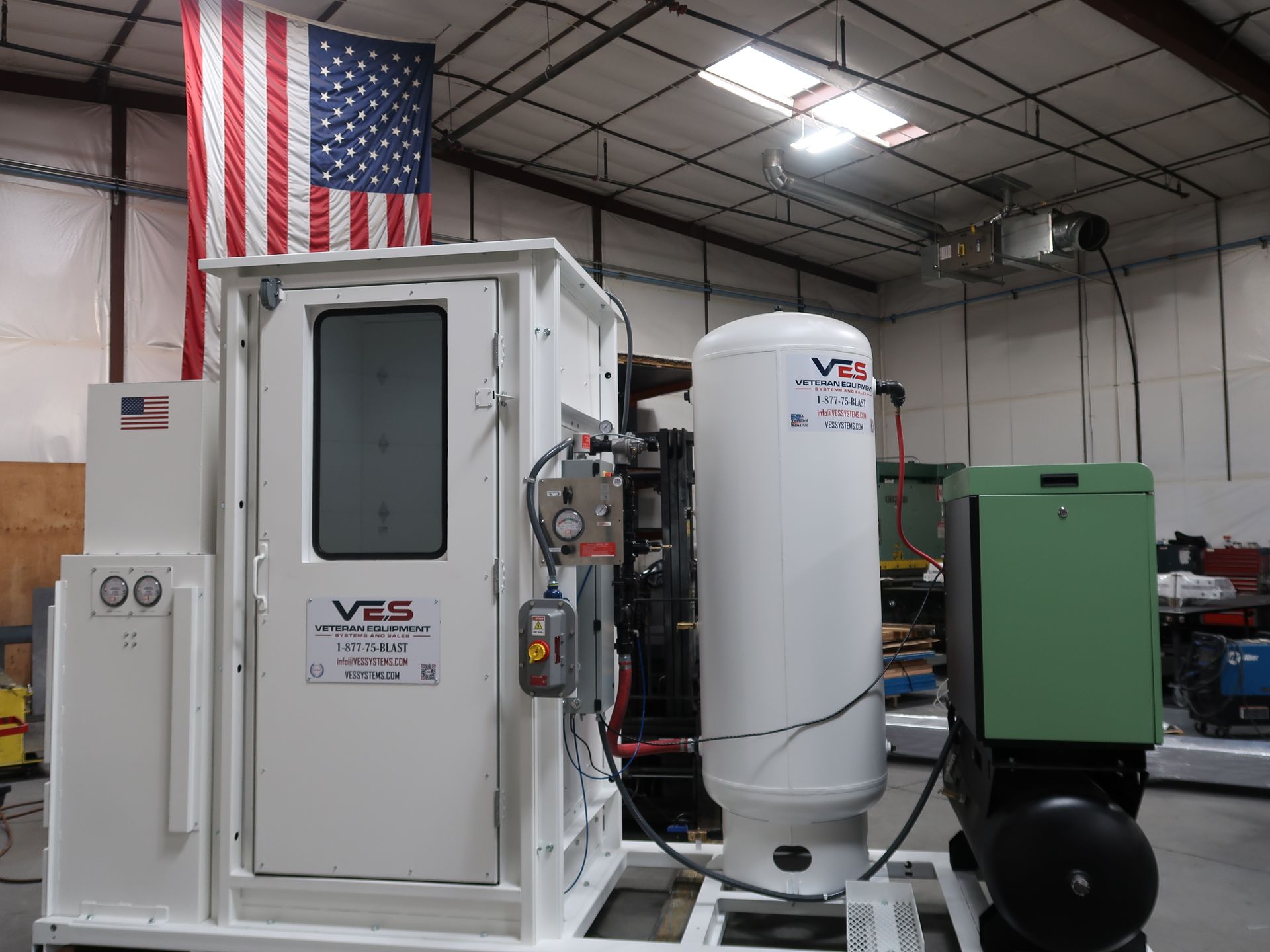 White air shower equipment with American flag, inside a workshop.