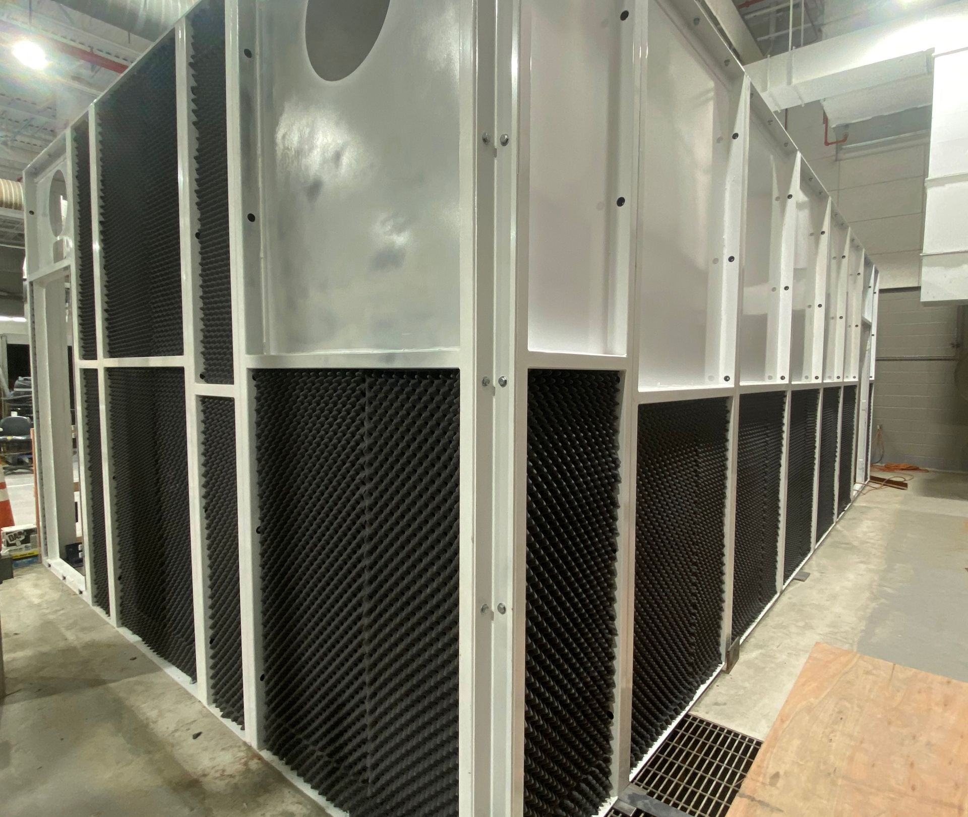 Interior of large white VES blast enclosure installed inside a facility.