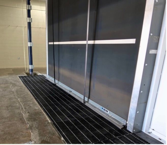 Exterior of large white VES blast enclosure installed inside a facility.