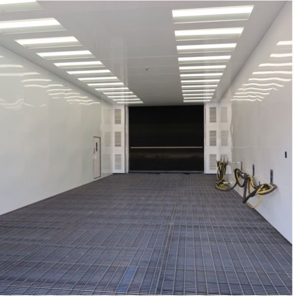 Interior of large white VES blast enclosure installed inside a facility.