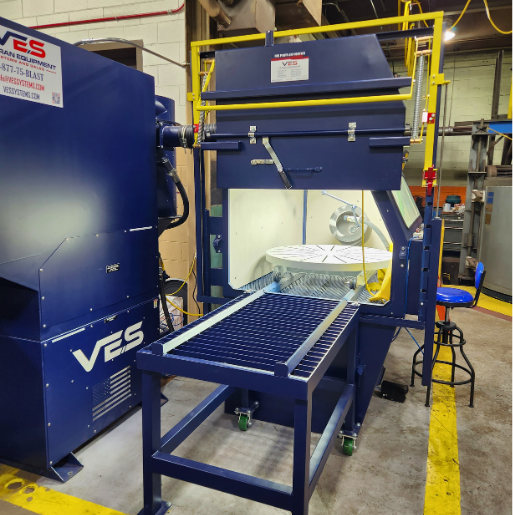 VES blast cabinet system with front work platform and integrated dust collection equipment in an industrial facility