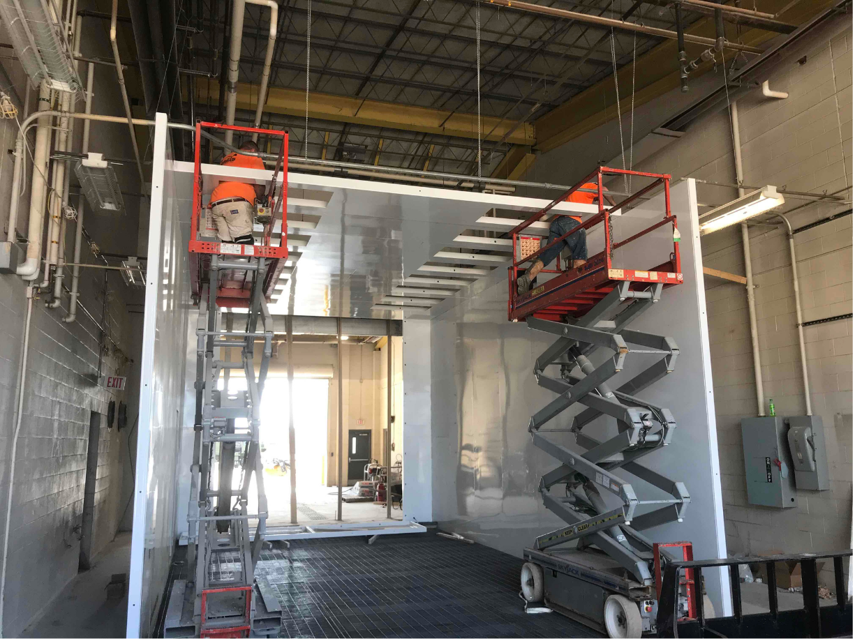 VES installation crew working on white drive thru industrial blast booth system