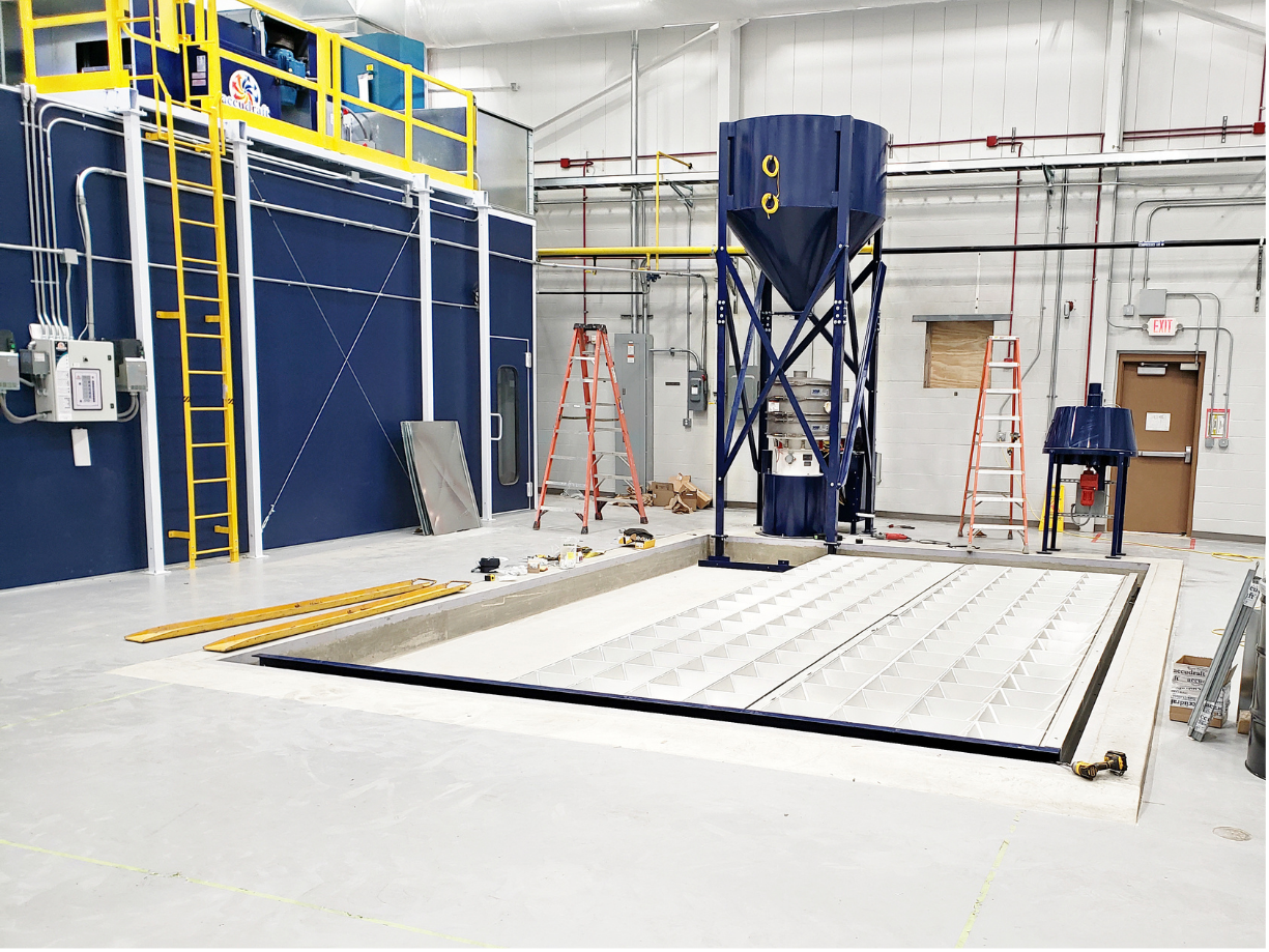 Blue VES industrial blast booth installation with blue dust collection equipment inside military facility