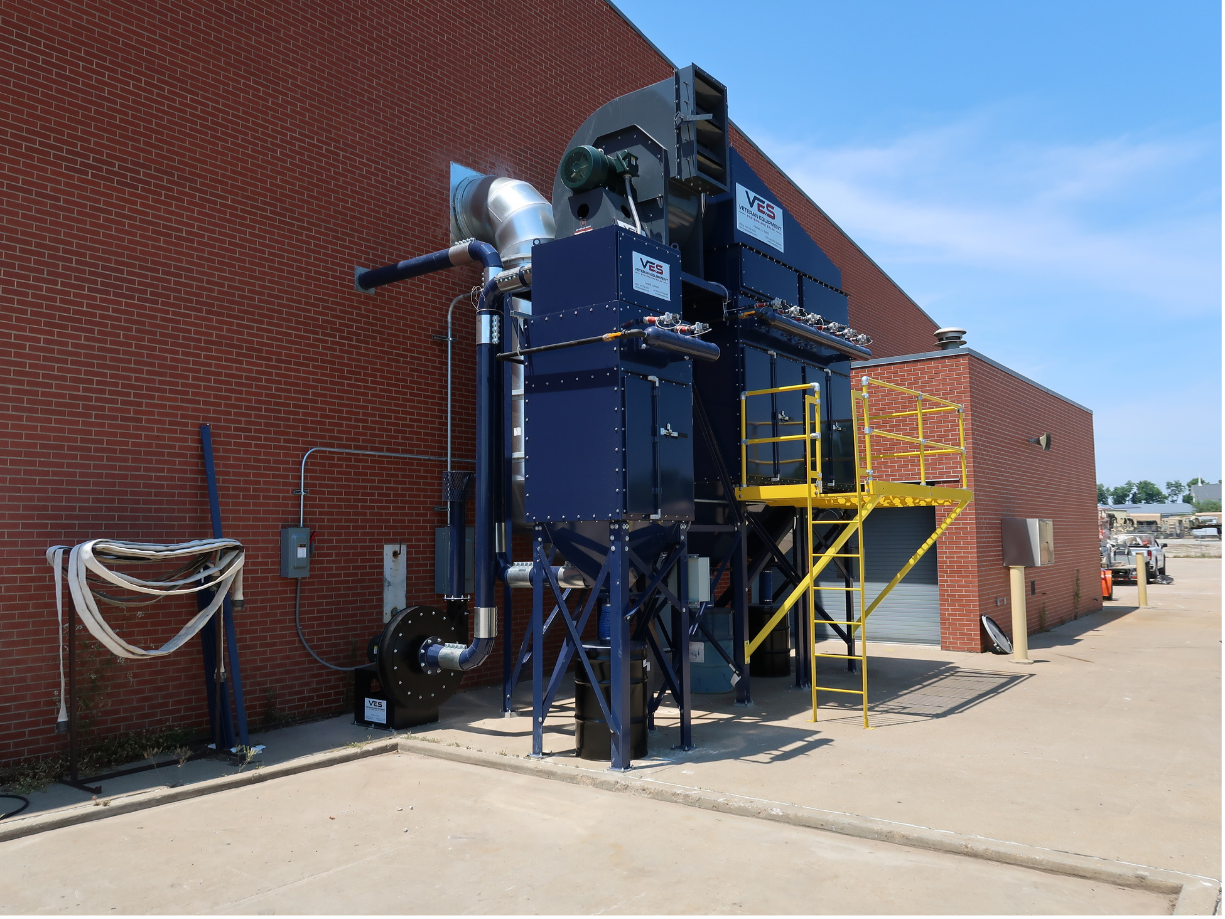 Outdoor blue VES dust collection system installed beside industrial facility