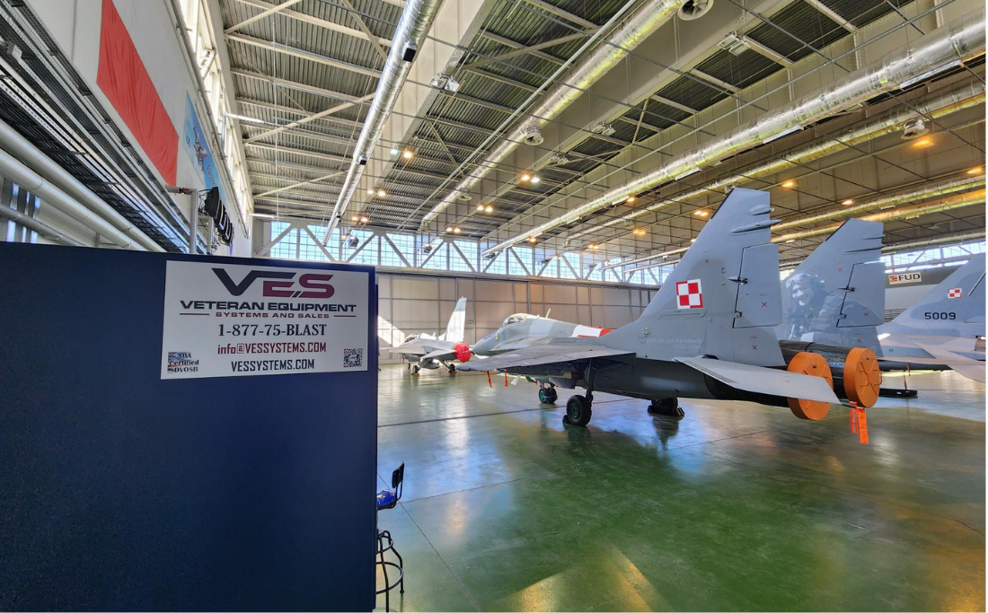 VES sign inside aircraft hangar next to a jet.