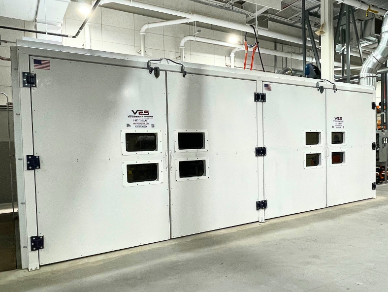 White VES blast enclosure with windows, access doors, and overhead support equipment.