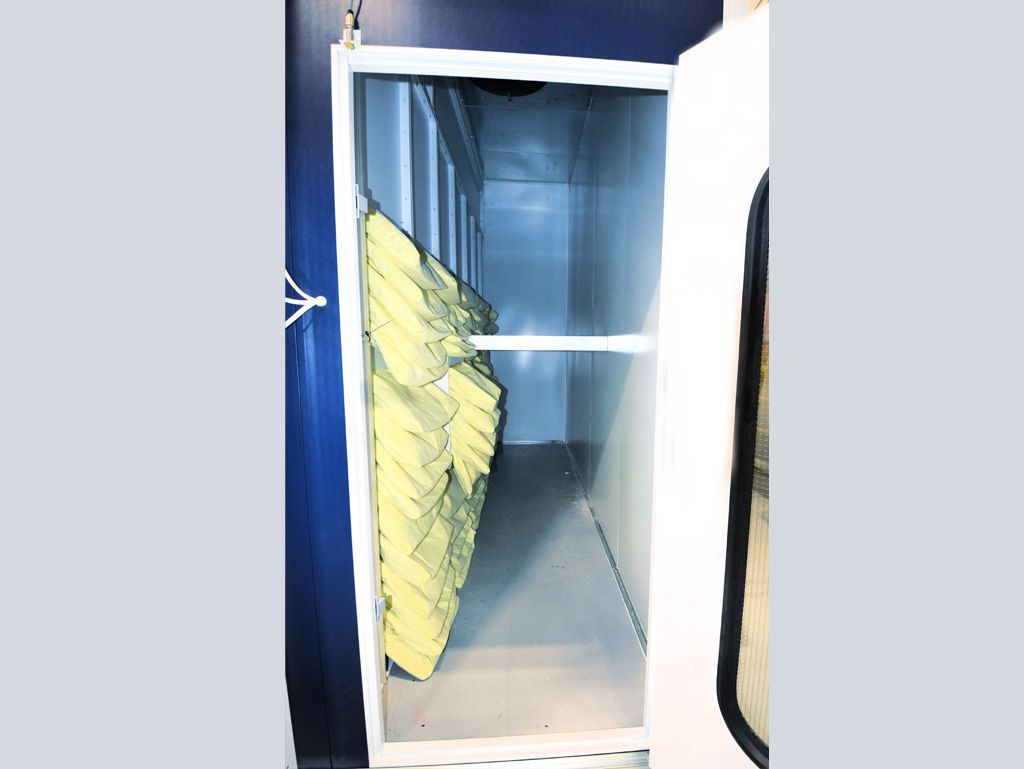 Open white rectangular chamber with light and stacked yellow filters hanging inside.