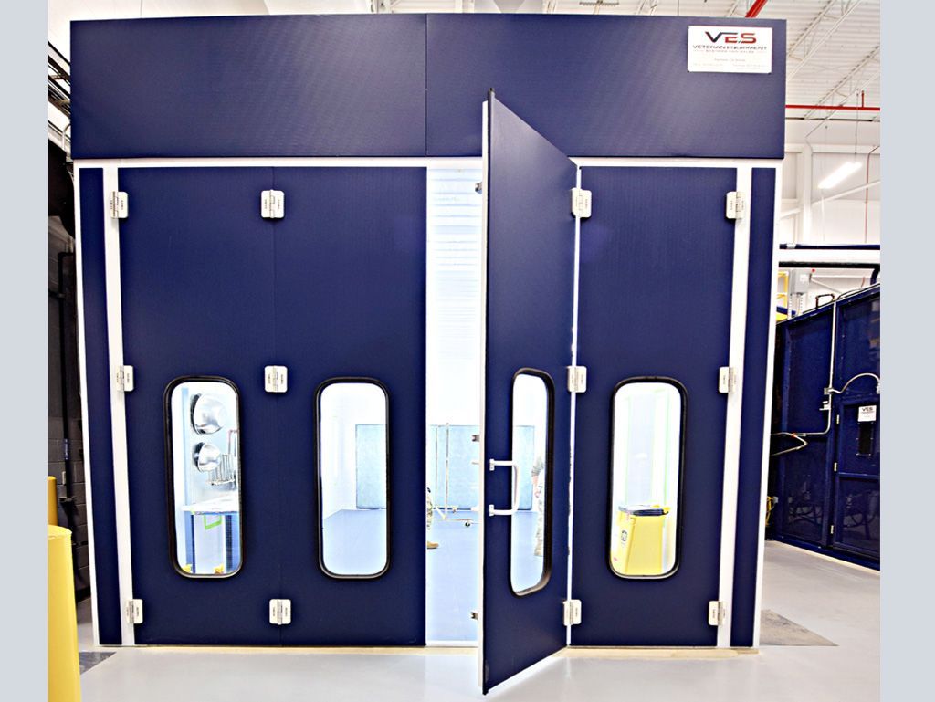 Blue paint booth with a door open, showing a window. White trim and the