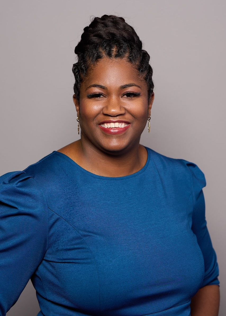 Smiling Crystal Arnold of Side Bar Talent in a blue top against a neutral gray background