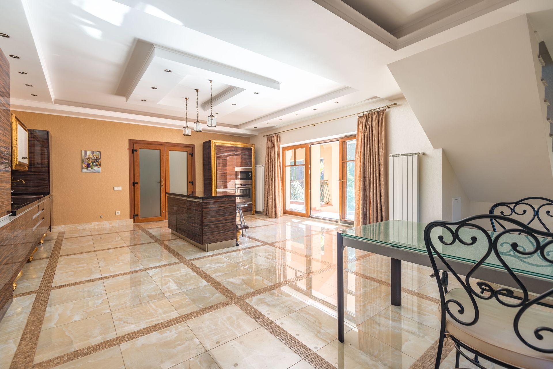 Bright modern room with marble floor, glass table, chandelier, and large windows