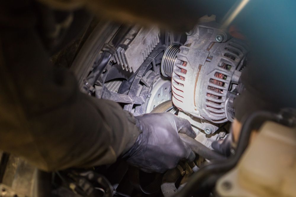 Mechanic is Working on a Car Engine, Near a Belt, Alternator, and Other Parts — Mareeba Motors In Mareeba, QLD