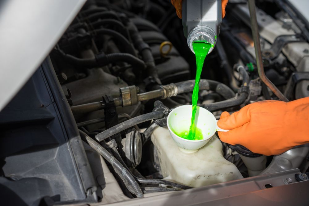 Mechanic Pouring Green Coolant Into a Car's Radiator — Mareeba Motors In Mareeba, QLD