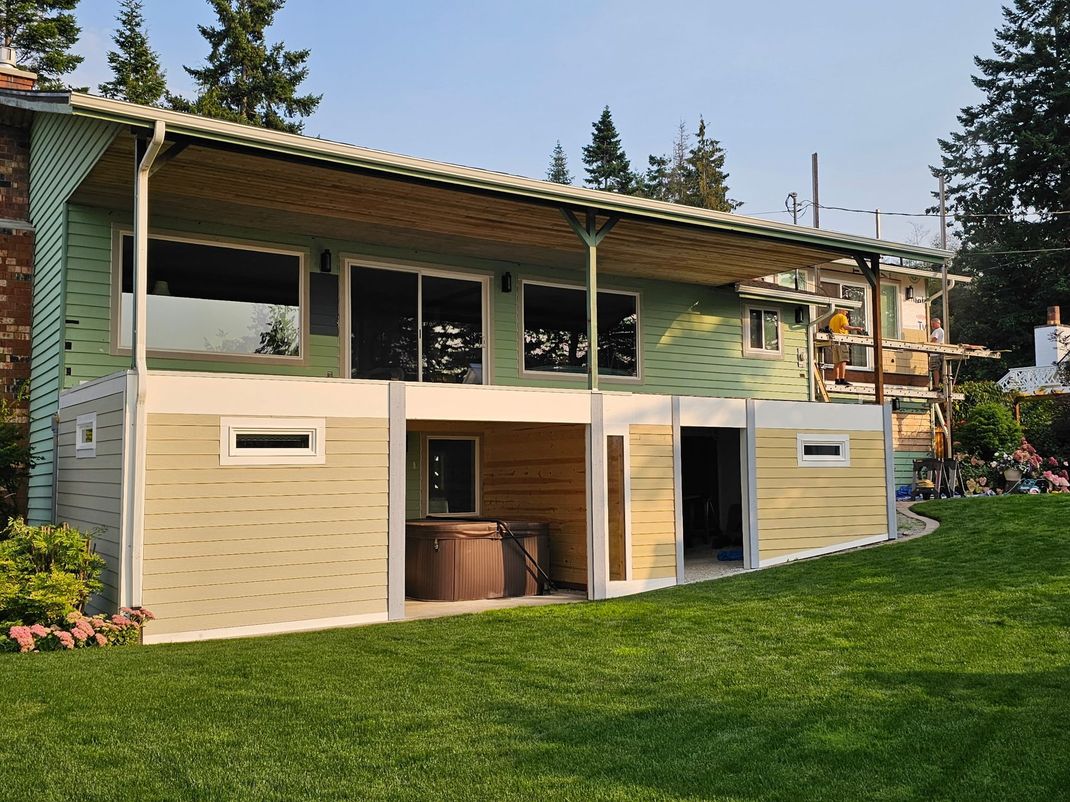 Backyard deck with a beige under-deck storage area and green lawn