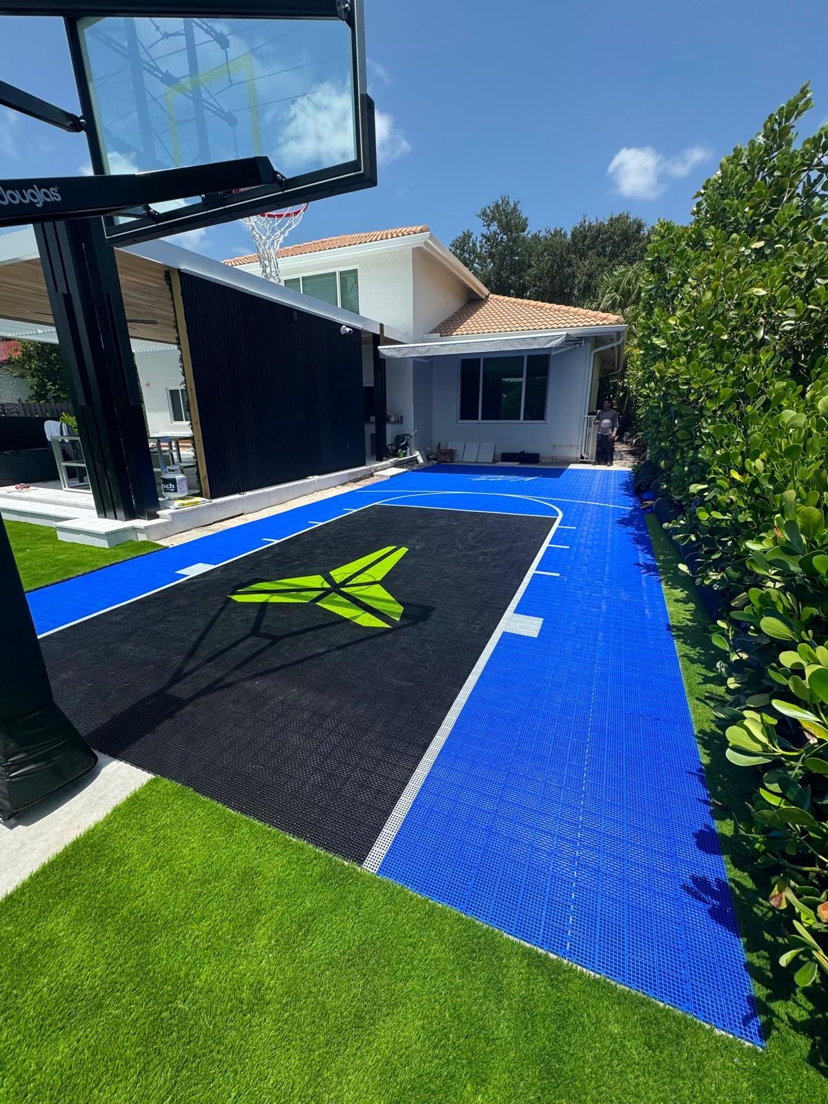 Finished backyard basketball court with black key and blue surface