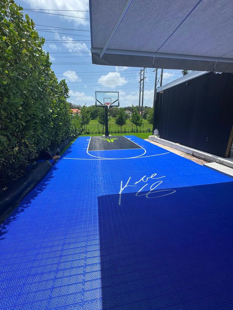 Blue modular court running down a Miami backyard toward the hoop