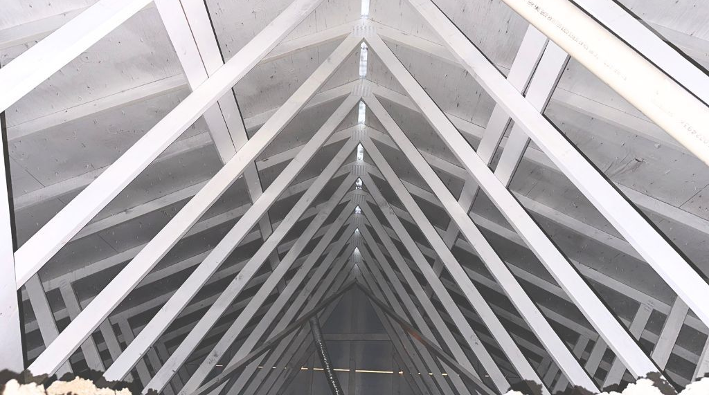 White-painted wooden rafters forming a triangular ceiling structure.