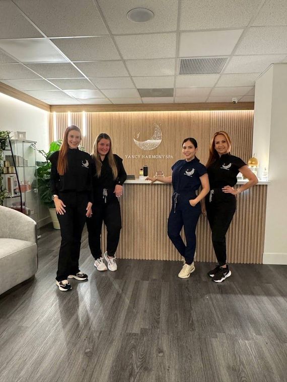 A group of women are standing in front of a counter in a room.