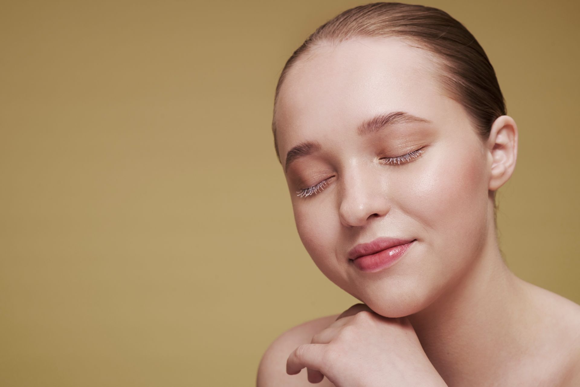 A close up of a woman 's face with her eyes closed.