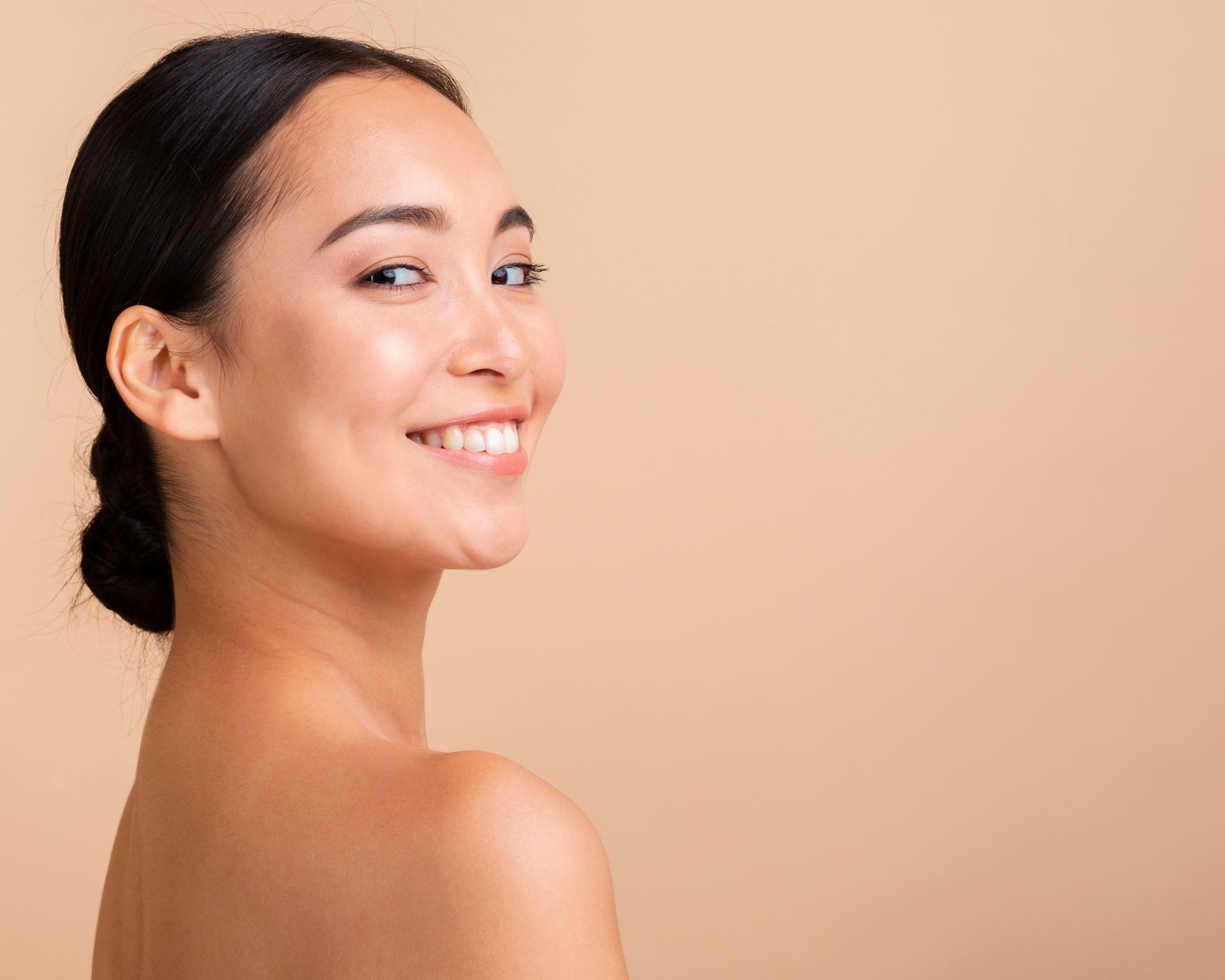 The woman is smiling and looking over her shoulder at the camera.