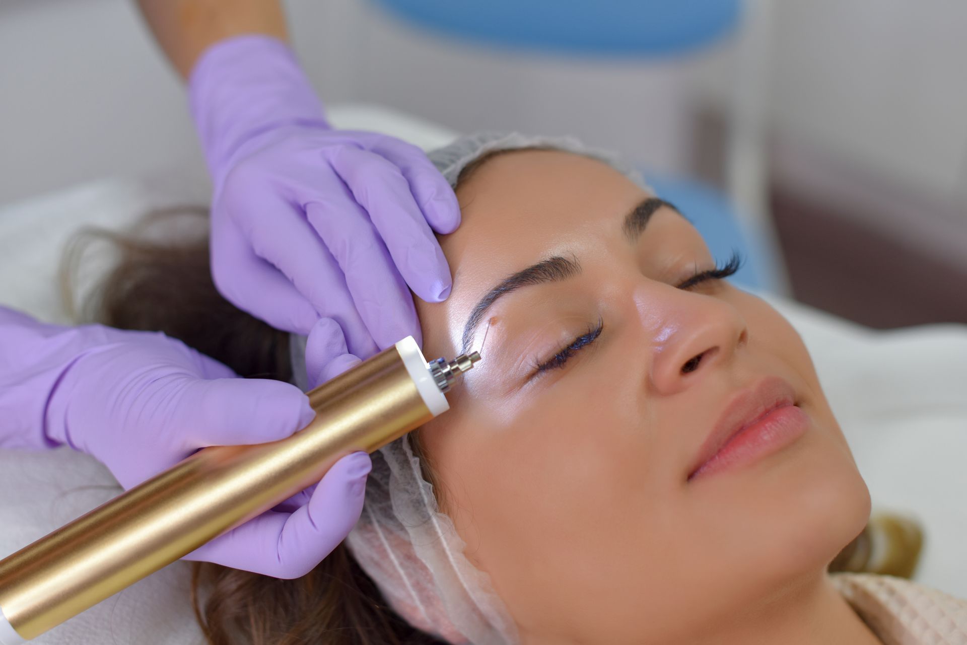 A woman is getting her eyebrows done in a beauty salon.