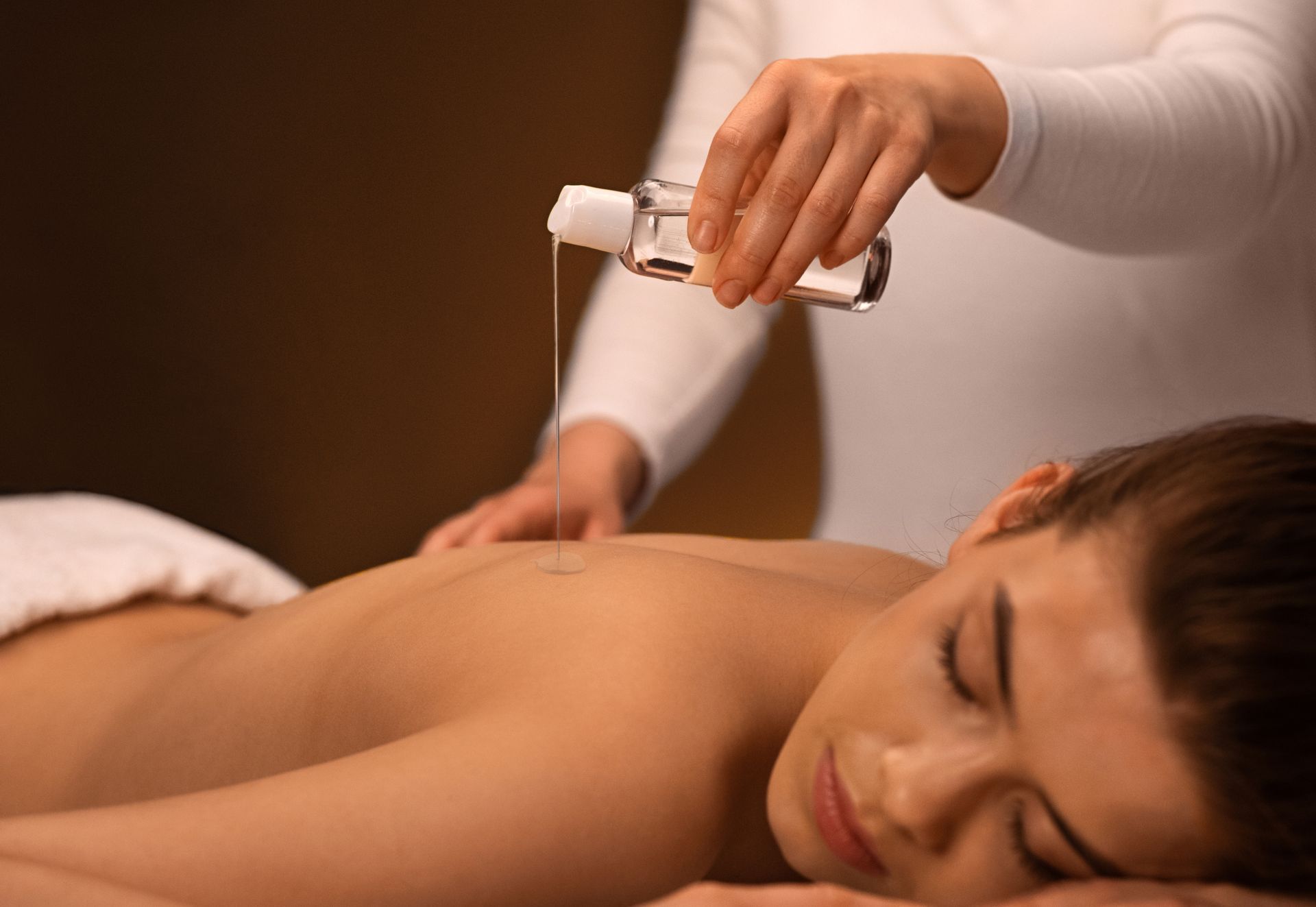 A woman is getting an oil massage at a spa.