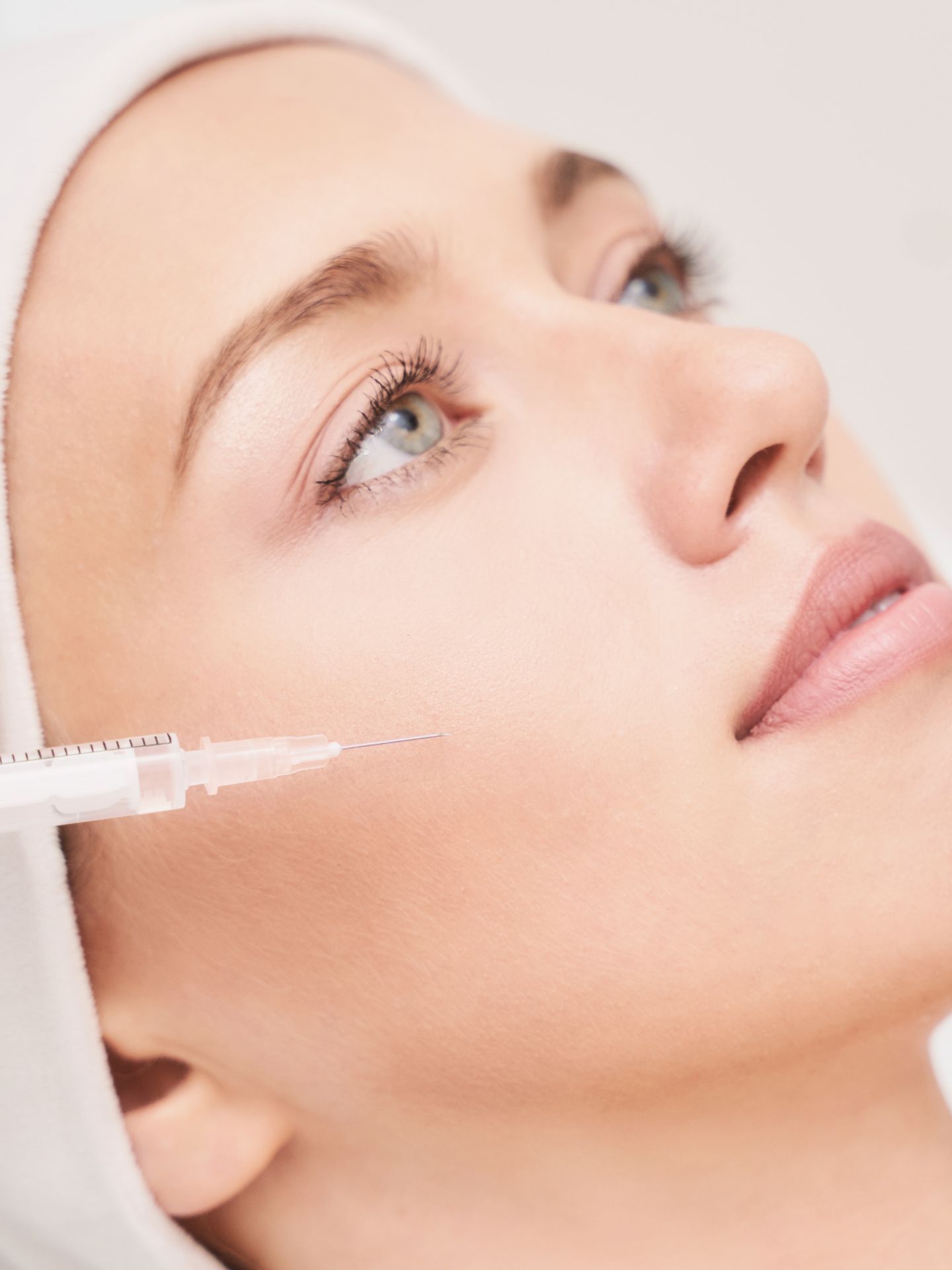 A woman is getting a botox injection in her face.