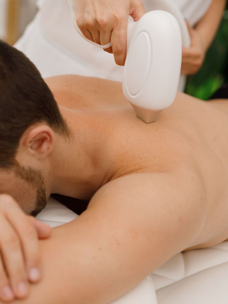 A man is getting a laser treatment on his back
