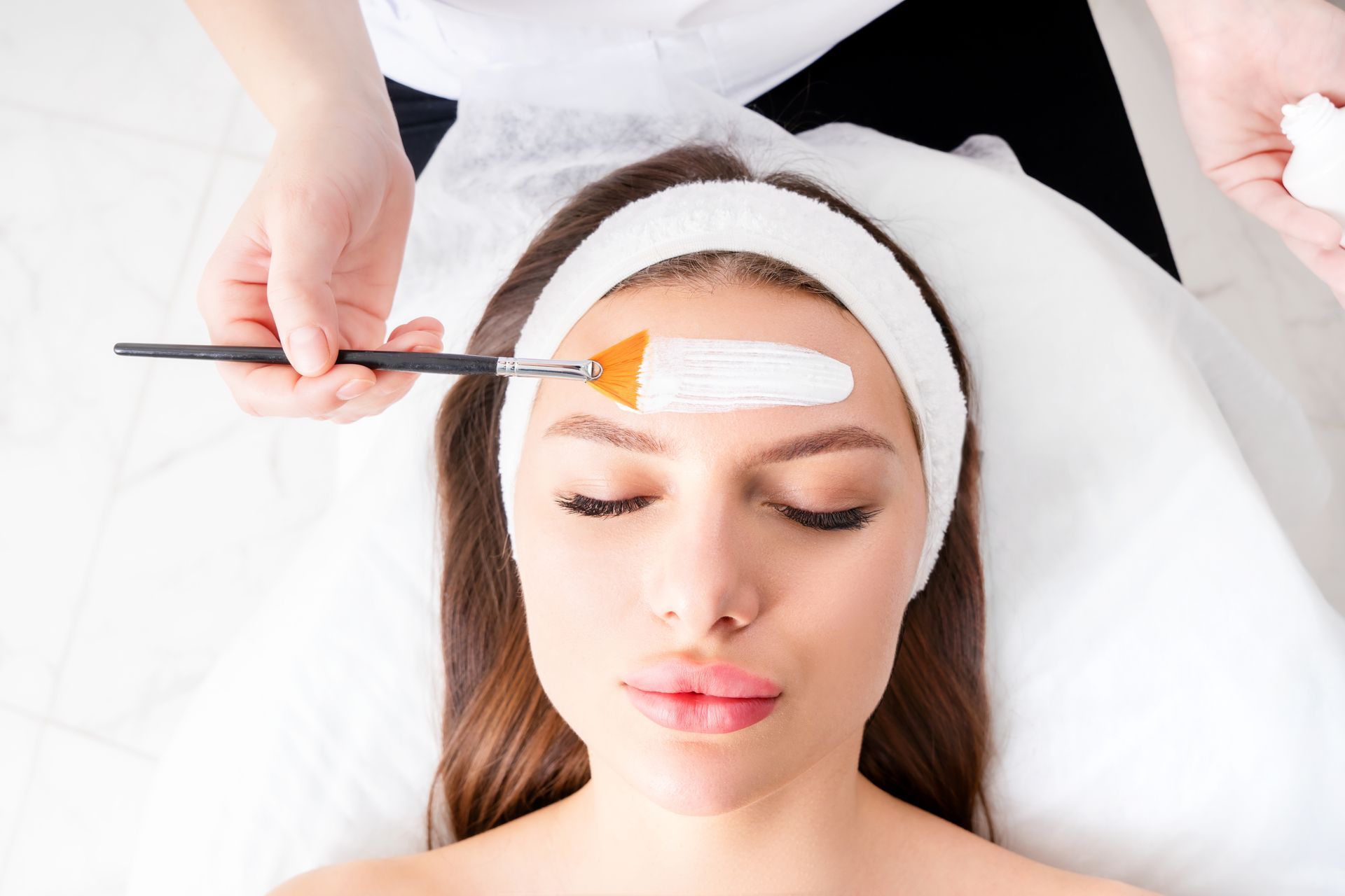 A woman is getting a facial treatment at a beauty salon.