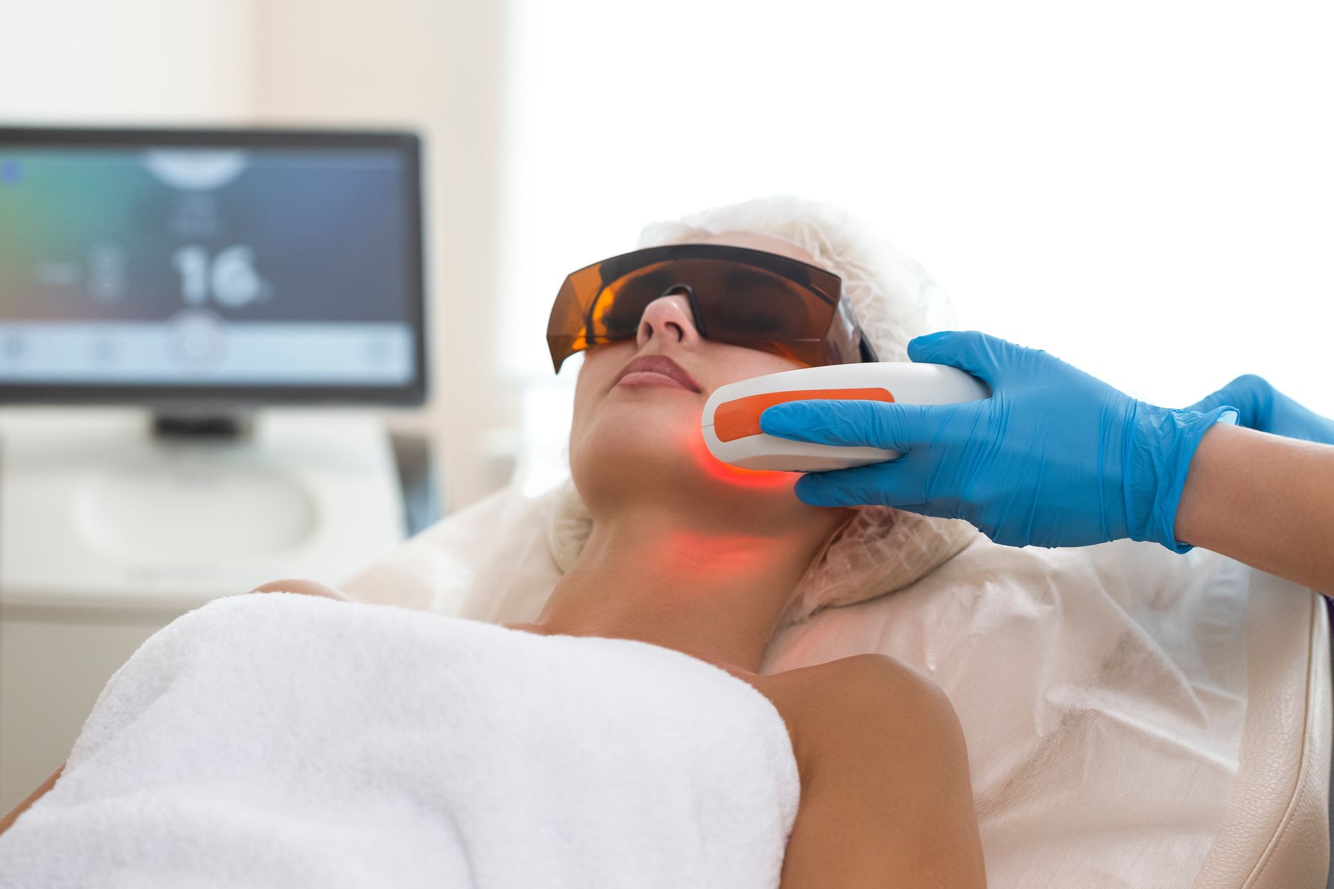 A woman is getting a laser treatment on her face.