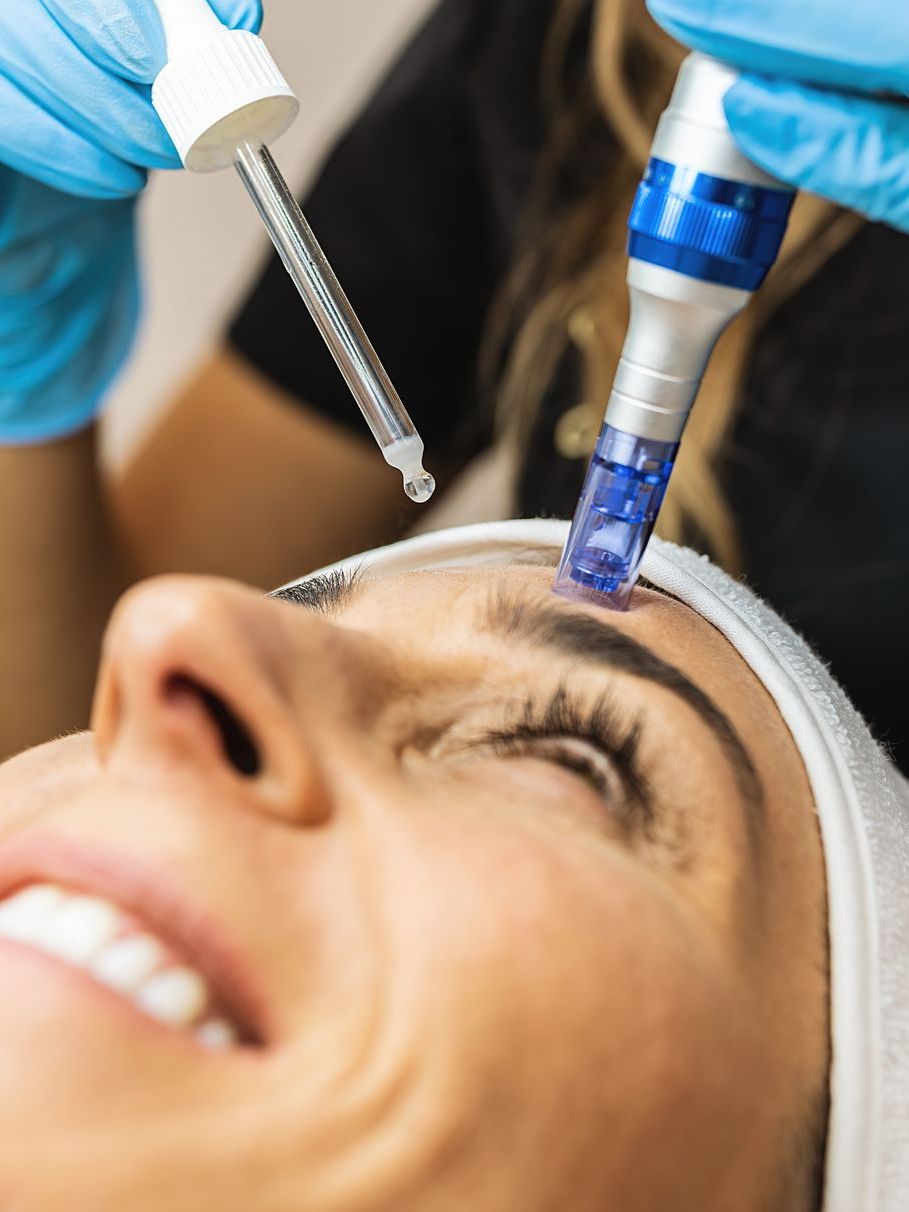 A woman is getting a treatment on her face.