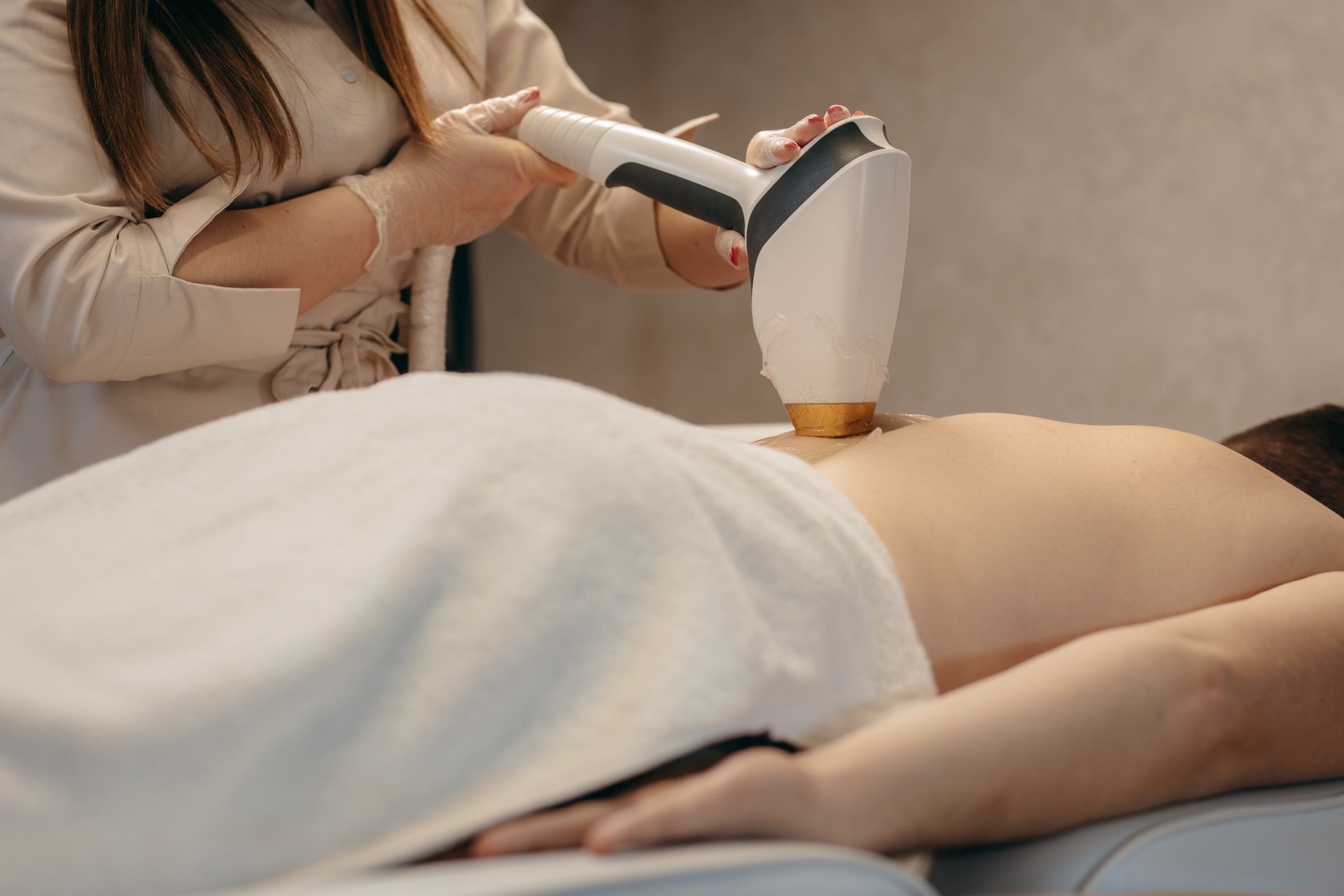 A woman is getting a laser hair removal treatment on her back.