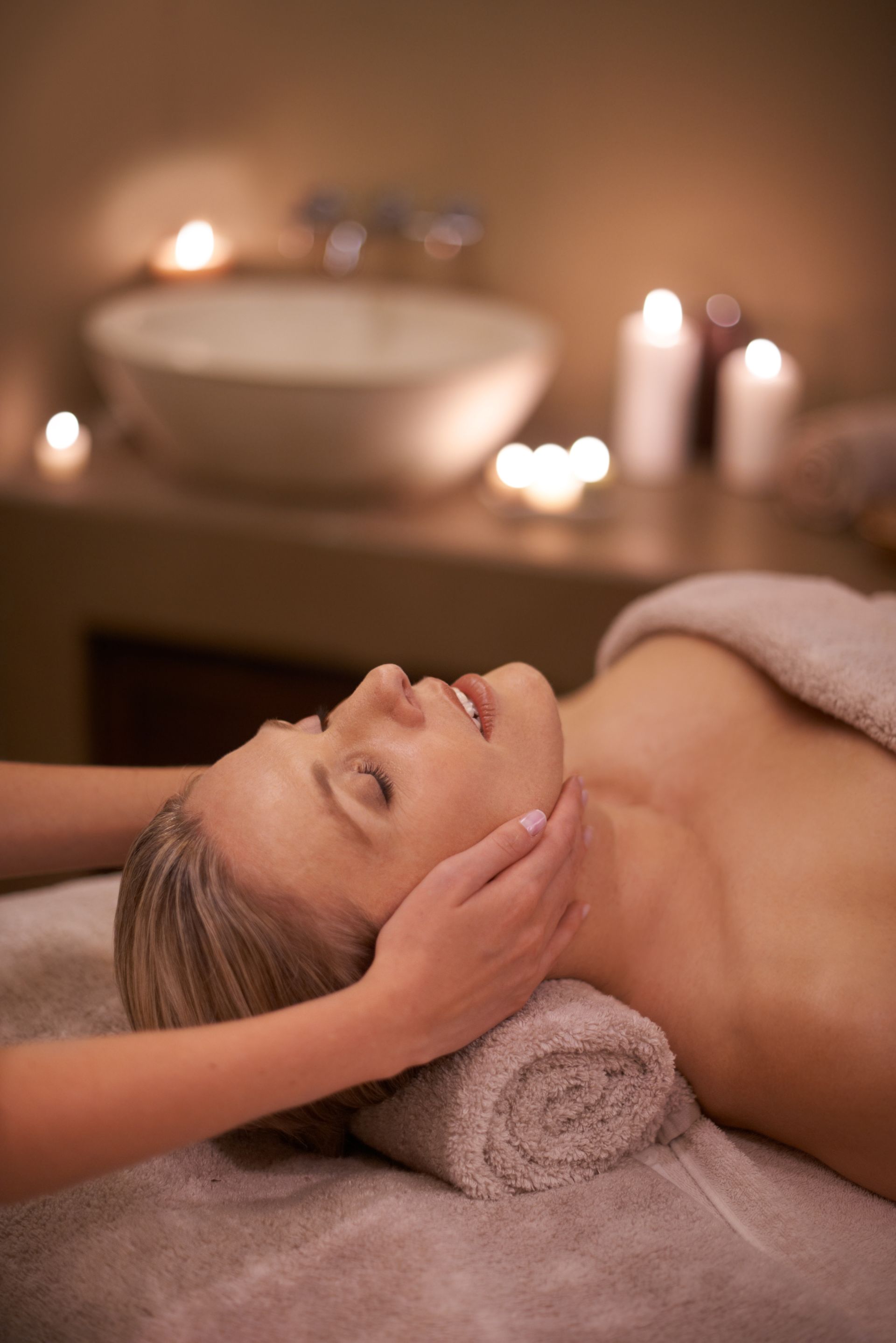A woman is getting a head massage at a spa.