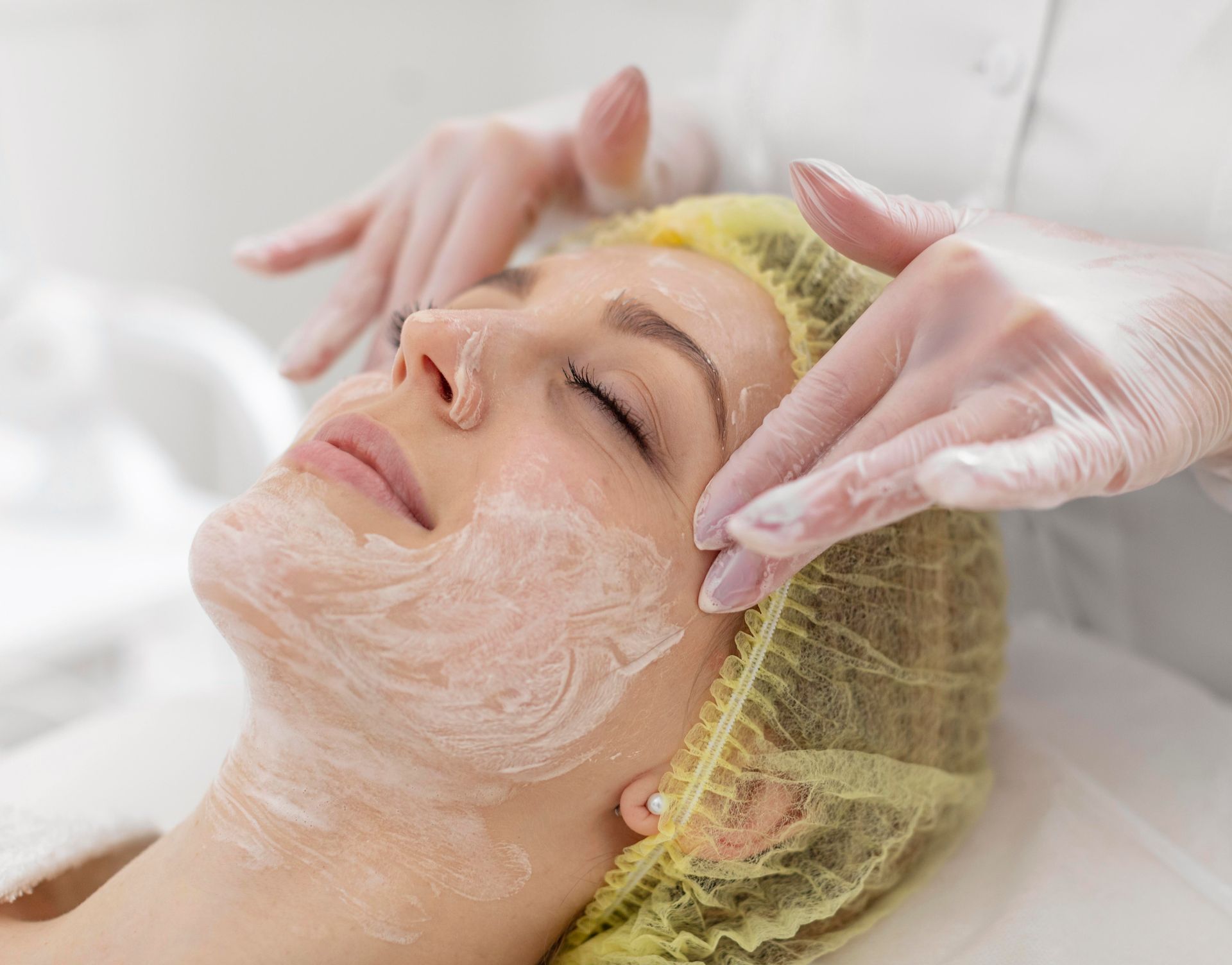 A woman is getting a facial treatment at a beauty salon.