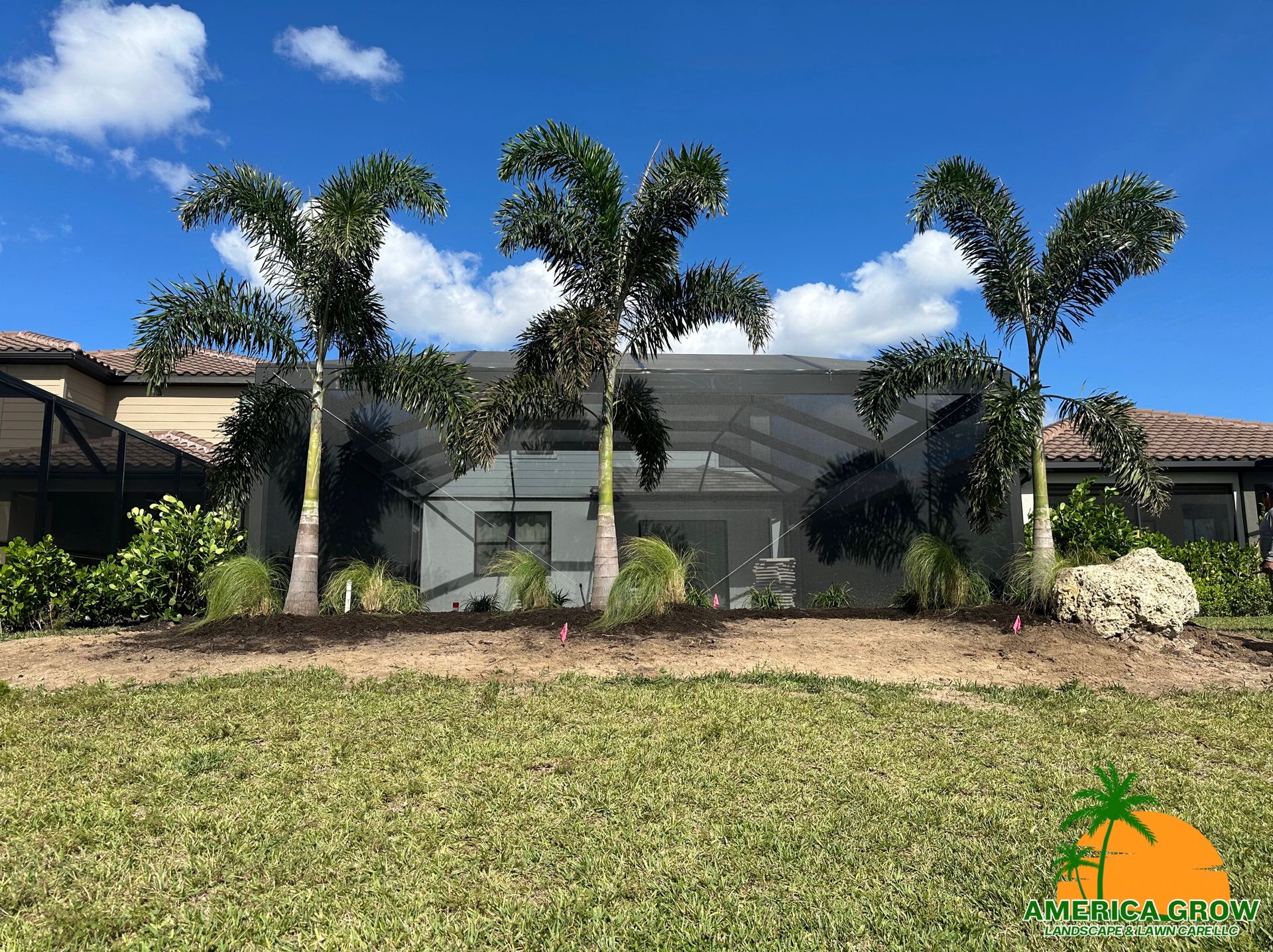 Palm trees in front of a screened patio on a sunny day.