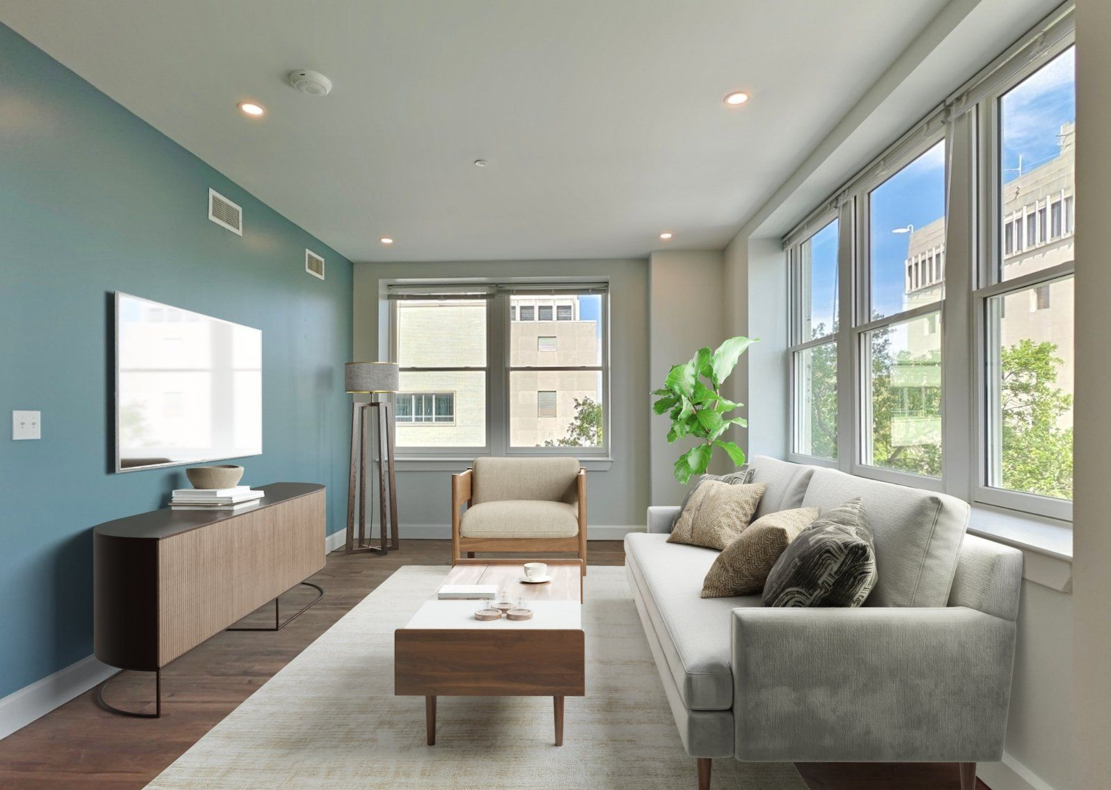 Living room with blue wall, sofa, armchair, coffee table, and large windows.