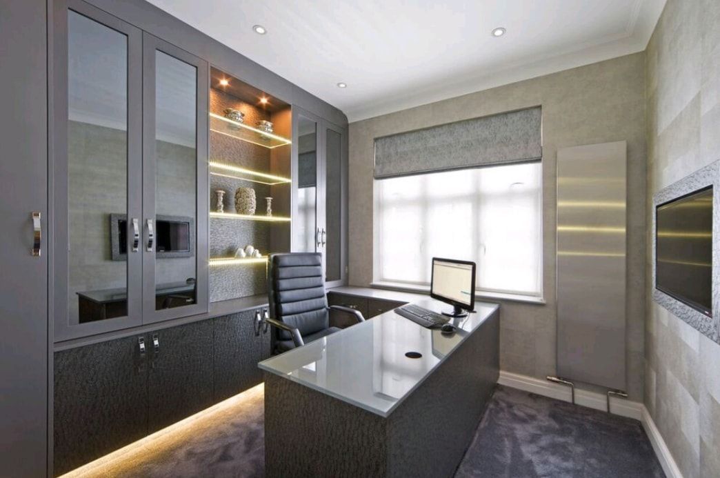 Modern home office with a desk, black chair, glass cabinets, and a large window.