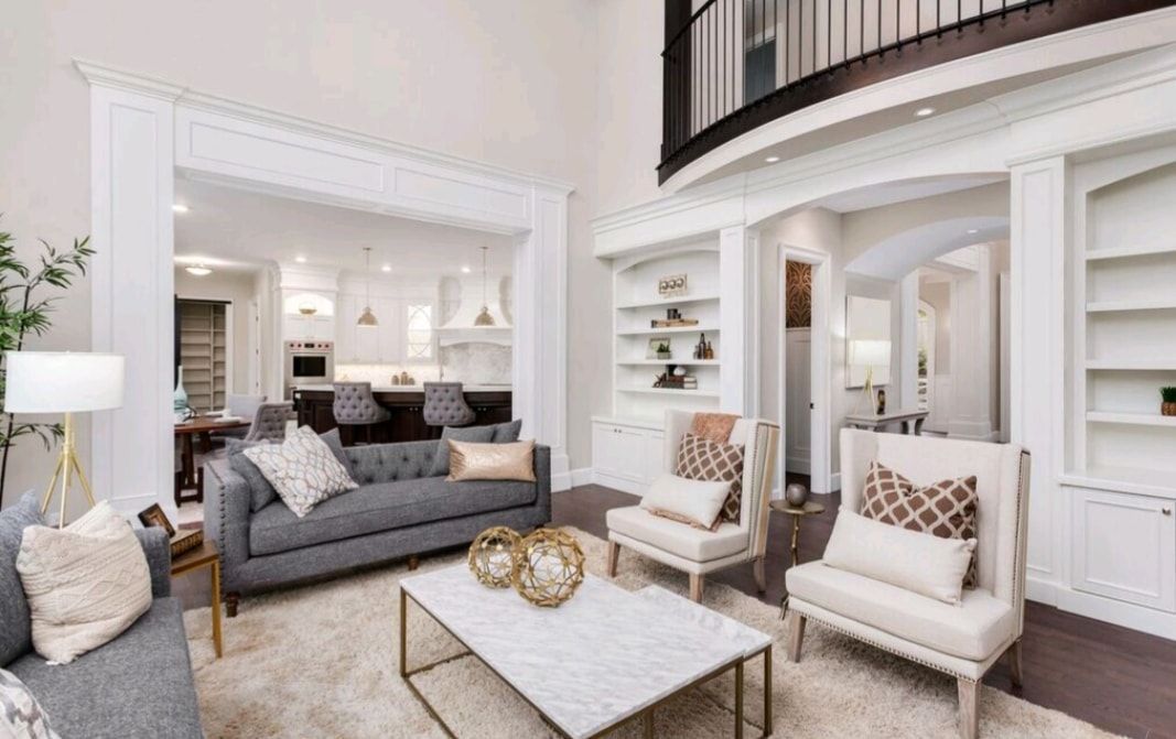 Elegant white living room with gray sofa, armchairs, fireplace, and a marble coffee table