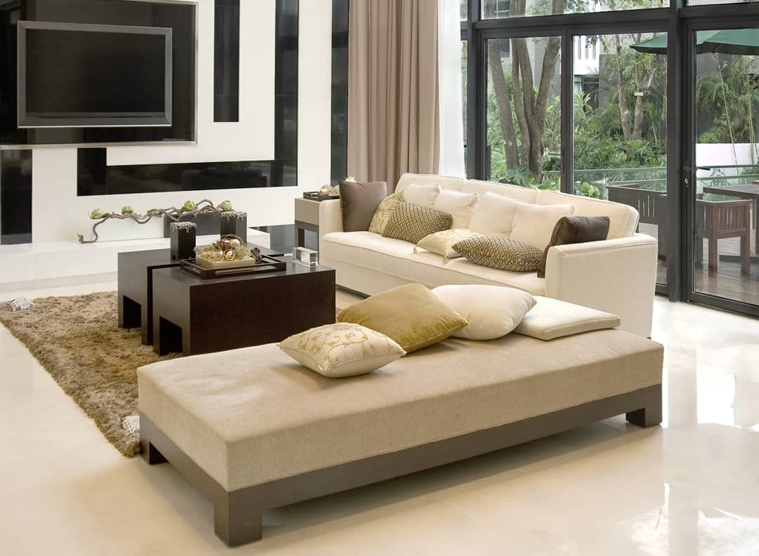 Modern living room with beige sectional, chaise lounge, coffee table, wall-mounted TV, and sliding glass doors