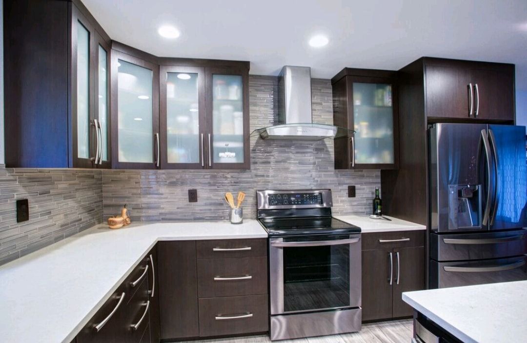 Modern kitchen with dark cabinets, stainless steel appliances, white countertops, and blue refrigerator