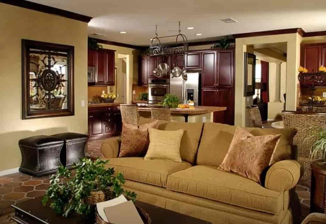 Warm living room with tan sofa, dark wood cabinets, chandelier, and decorative wall art
