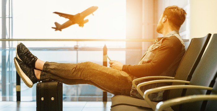 Passenger waiting in the airport watching a plane takeoff