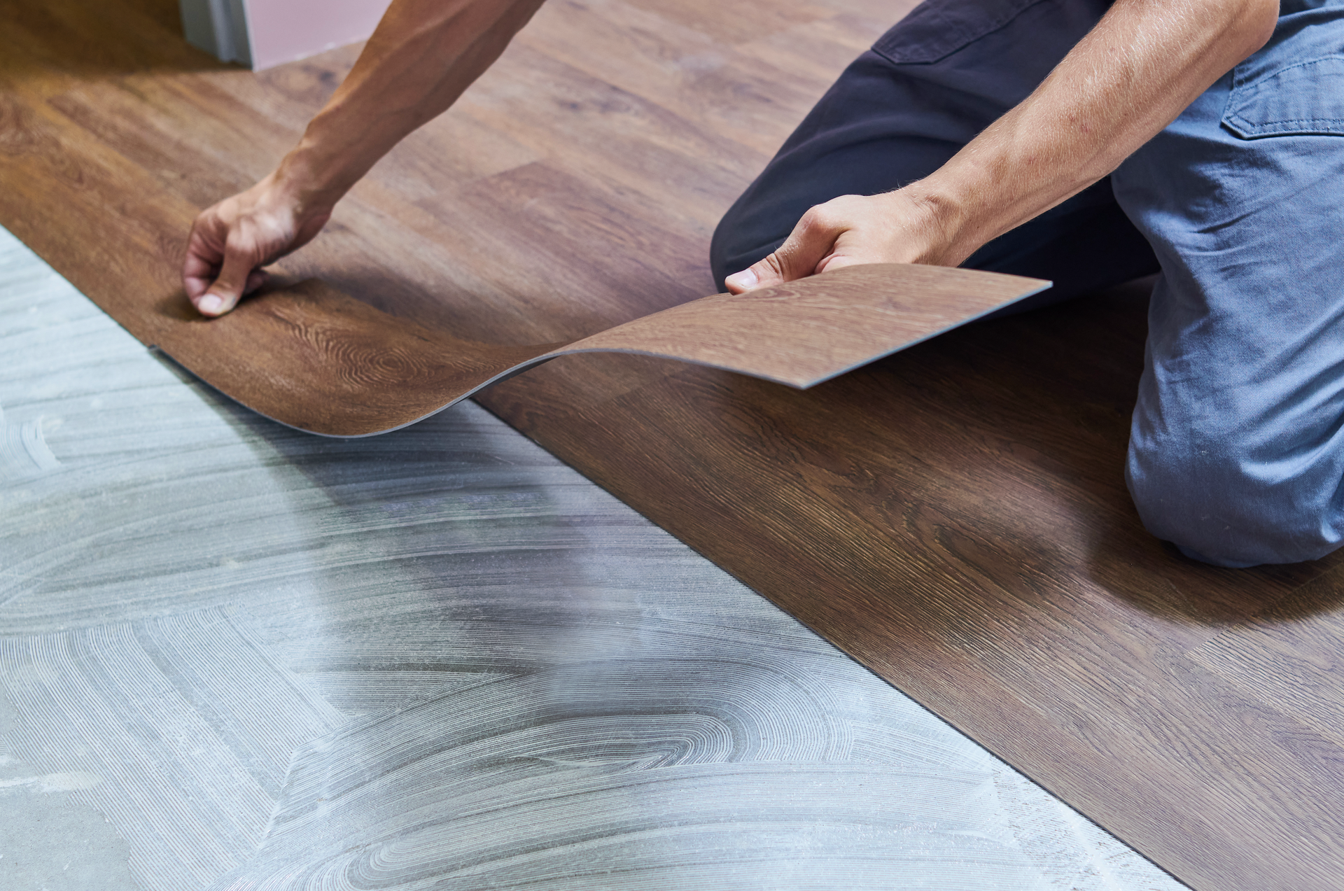 A person is installing a wooden floor in a room.