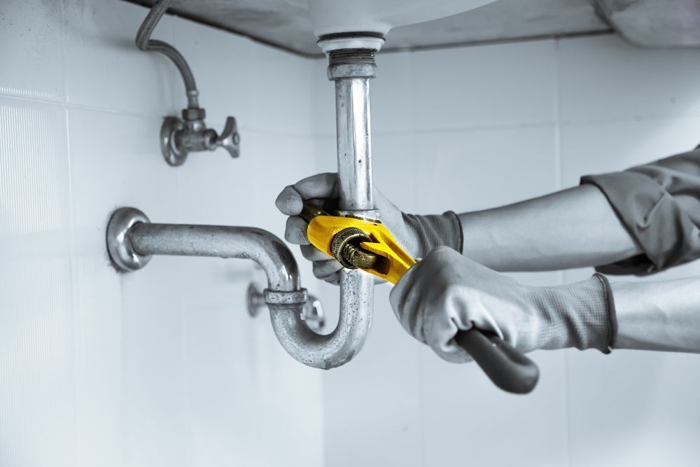 Plumber Using Wrench to Repair Sink Pipes — Waves Plumbing in Lake Macquarie, NSW