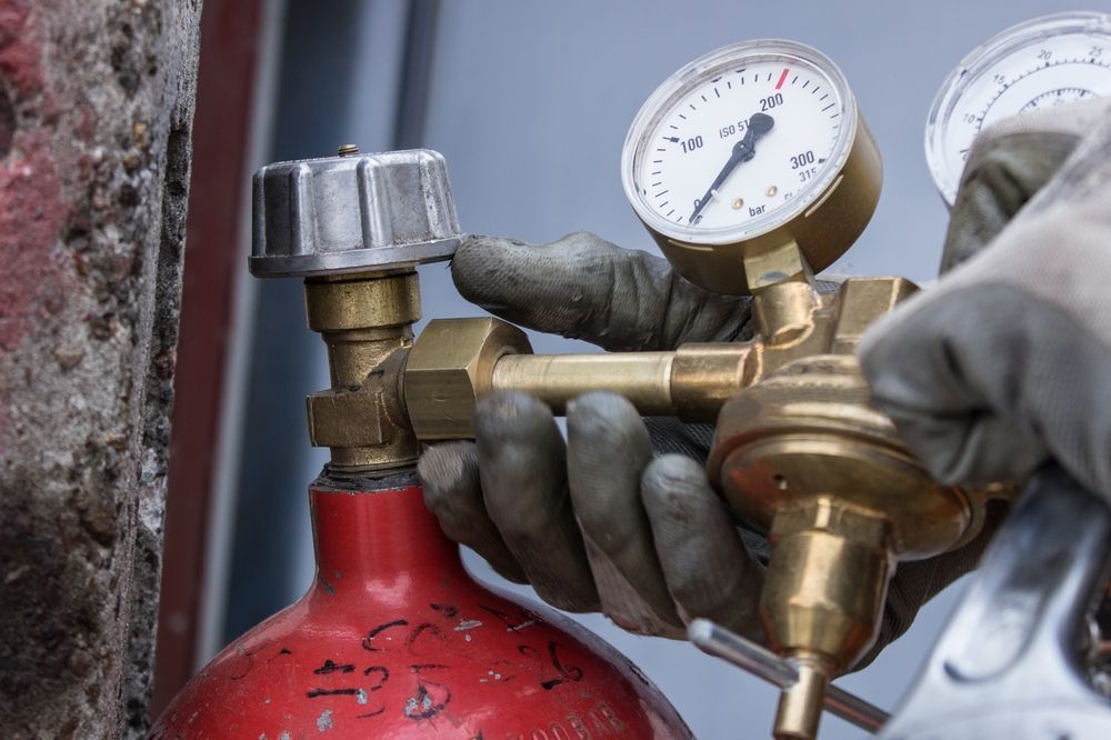 Person in Gloves Adjusting a Pressure Regulator — Waves Plumbing in Woy Woy, NSW