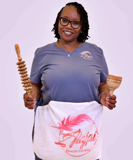 A woman in a blue shirt is holding a towel and a wooden stick