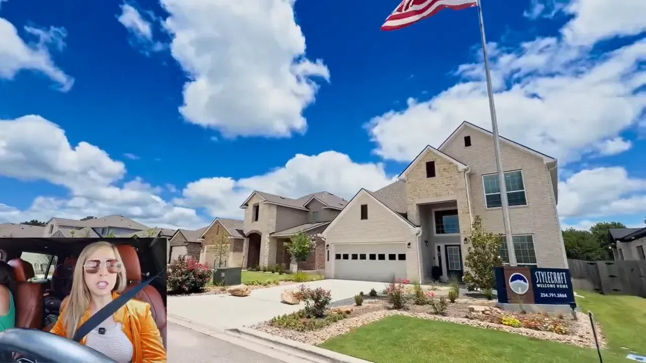 Large newer homes with stone exteriors garages and flags in front yards