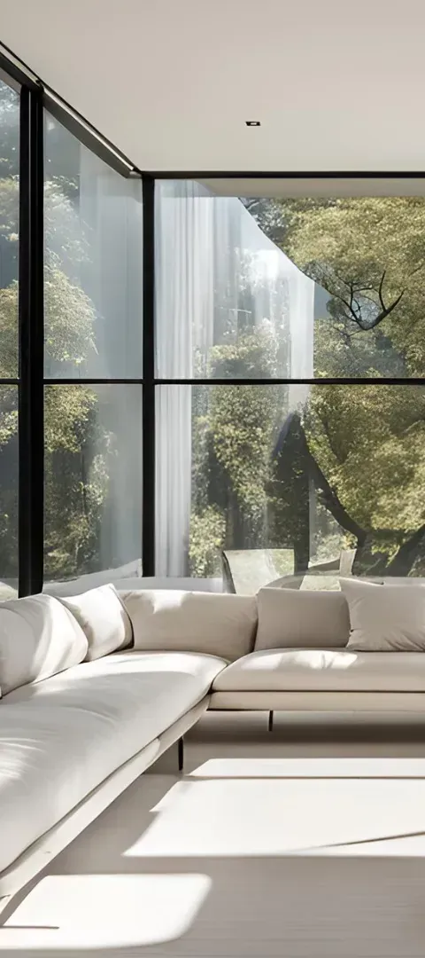 Bright modern living room with large floor-to-ceiling windows and a white sectional sofa