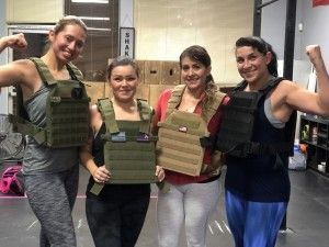 A group of women wearing weighted vests are posing for a picture.